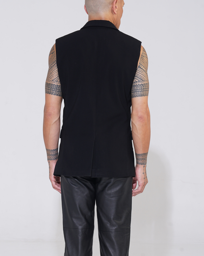 Black tailored sleeveless jacket with two-button front on male model with Endemann leather pants, back view