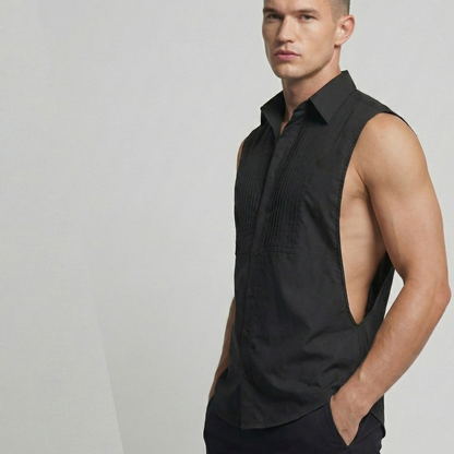 Man wearing a black sleeveless shirt against a plain background
