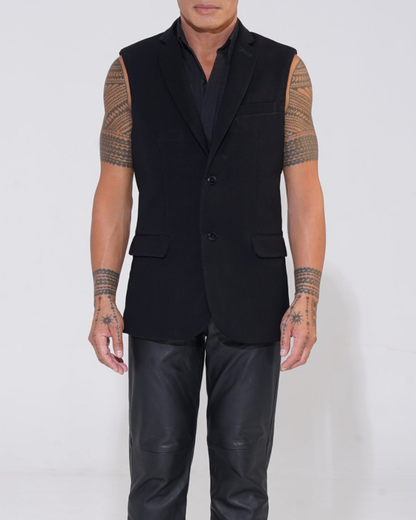 Black tailored sleeveless jacket with two-button front on male model with Endemann leather pants