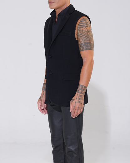 Black tailored sleeveless jacket with two-button front on male model with Endemann leather pants