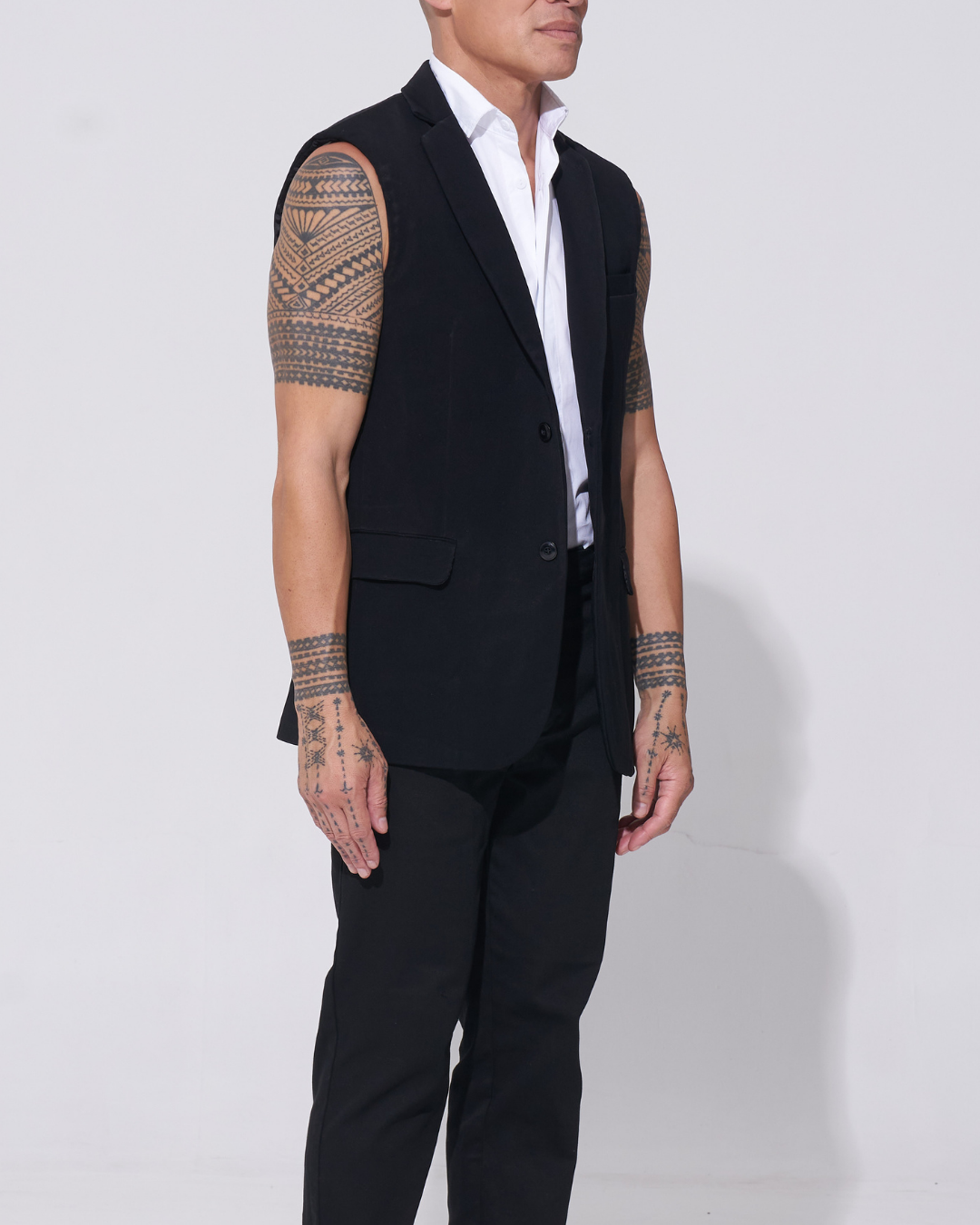 Black tailored sleeveless jacket with two-button front over an endemann white sleeveless shirt on male model