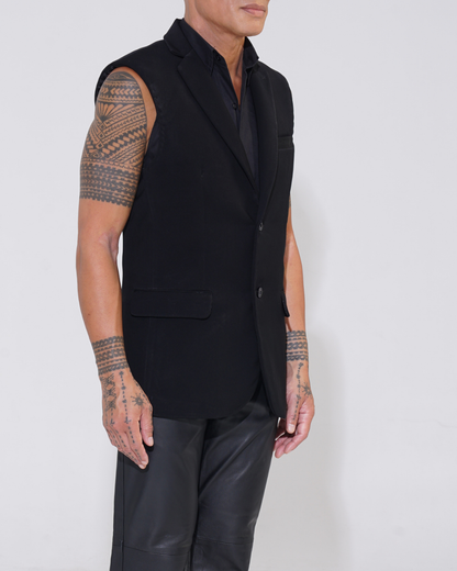 Black tailored sleeveless jacket with two-button front on male model with Endemann leather pants