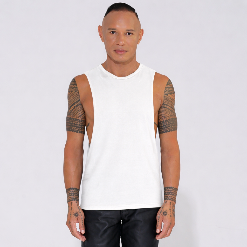 Man wearing a white sleeveless tank top with deep sides with arm tattoos 