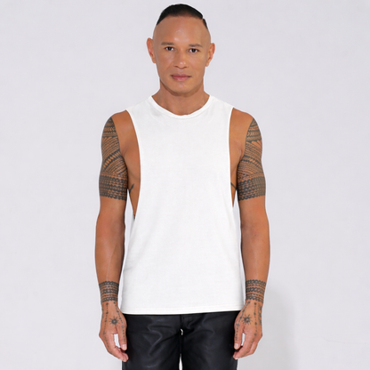 Man wearing a white sleeveless tank top with deep sides with arm tattoos 