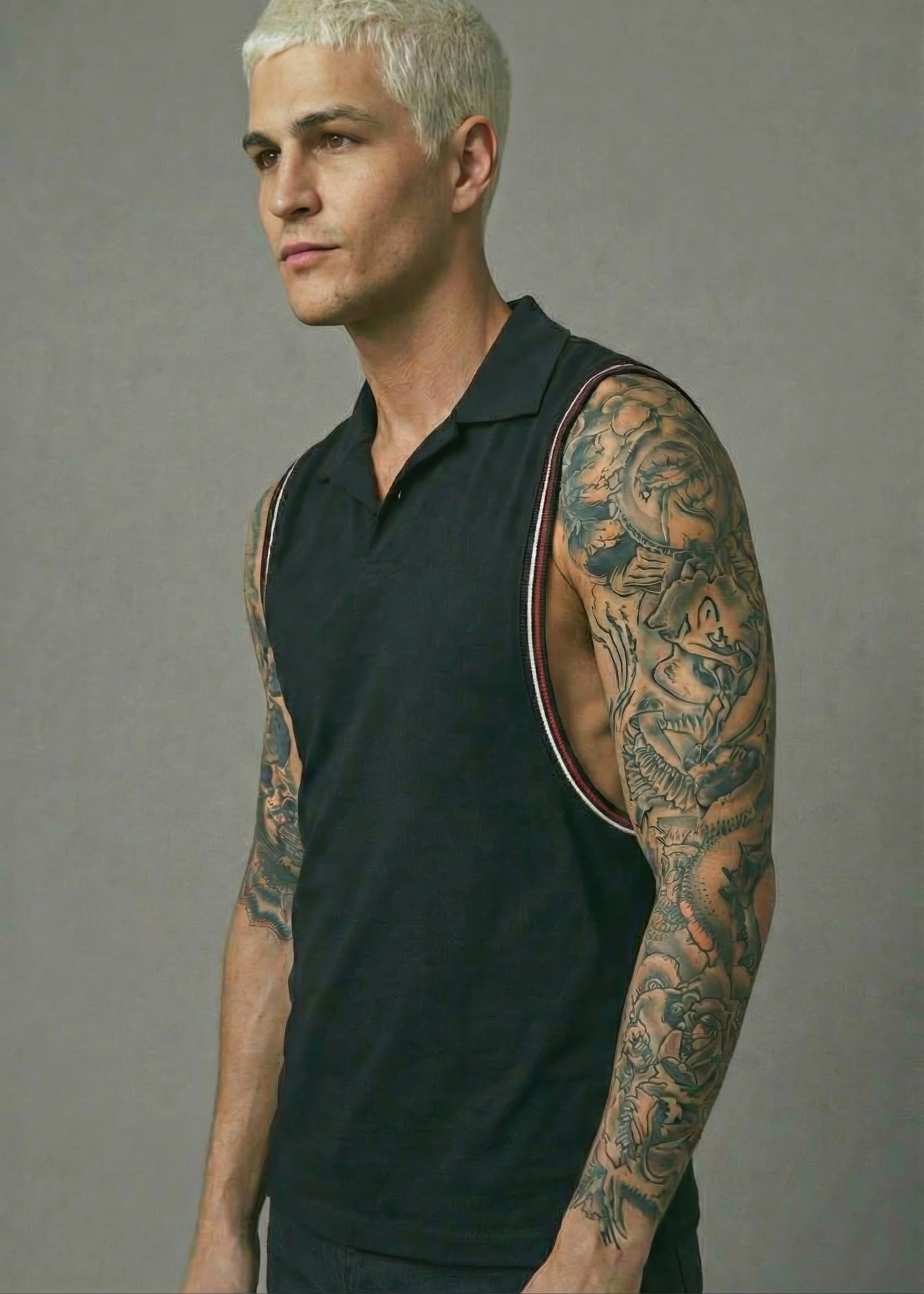 Man with tattoos on arms wearing a black sleeveless shirt 
