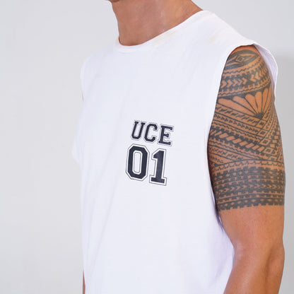 Person wearing a white sleeveless shirt with 'UCE 01' text and displaying a tattooed arm.