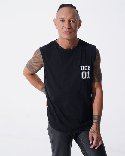 Man wearing a black sleeveless shirt with 'UCE 01' text on a white background